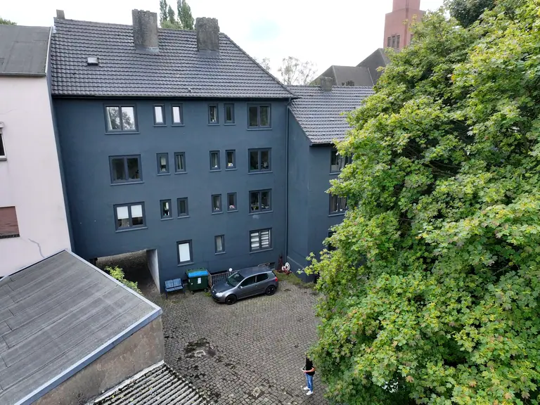 Rückseite der Mehrfamilienhäuser am Pothmannsweg mit Innenhof, Stellplätzen und Bäumen